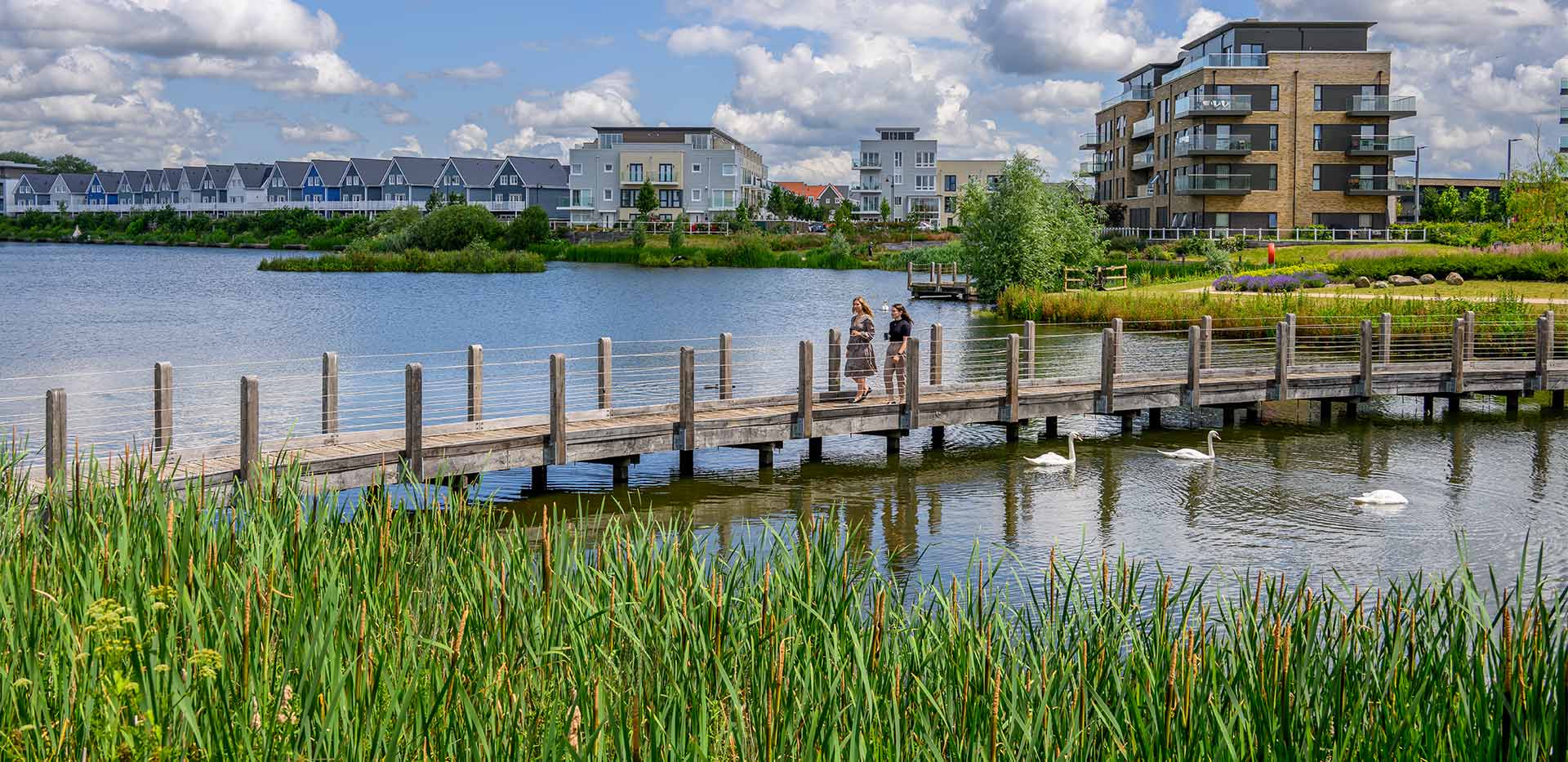 Green Park Village lake with two women walking along the bridge