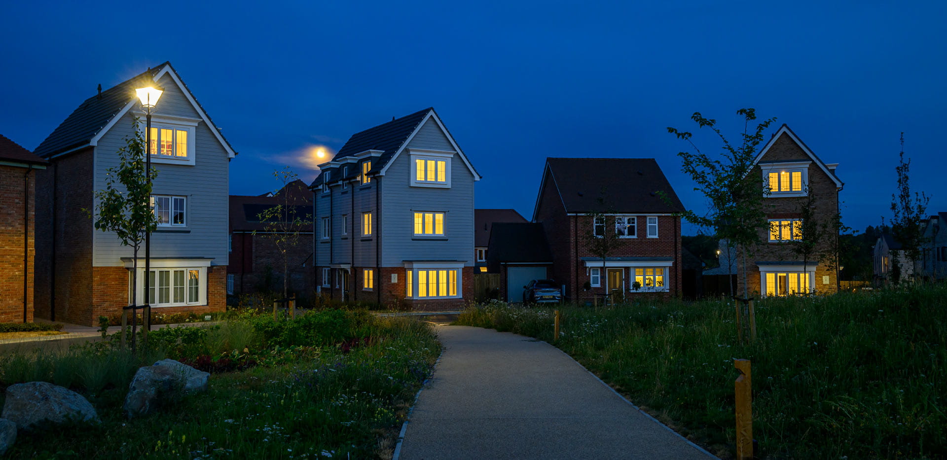 New build homes in the evening with well maintained grassed path in front.