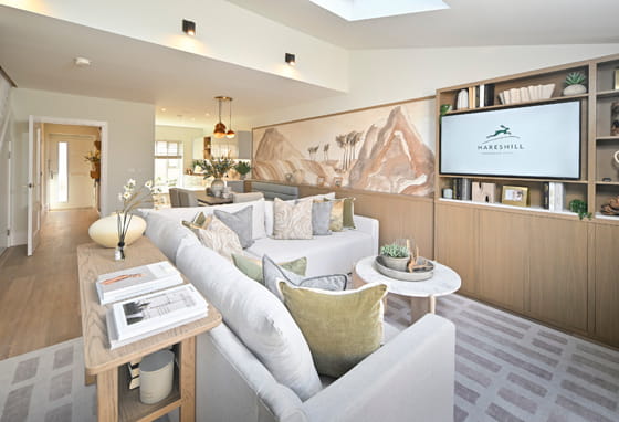 Decorated interior living space: TV mounted on wall, wall hangings, sofa and tables