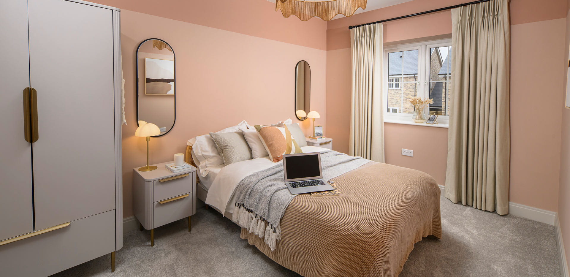 Double bed with light pink walls, grey wardrobe and bedside tables