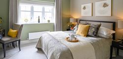 Large bedroom with central double bed and sage and yellow decor