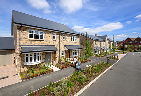 View of a new build home with private drive, garage, landscaped front.