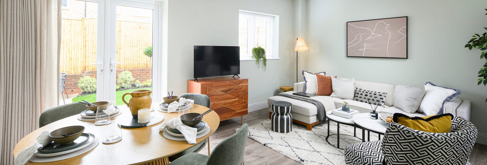 Living space with round dining table, carpet on wood flooring, sofa and coffee table.