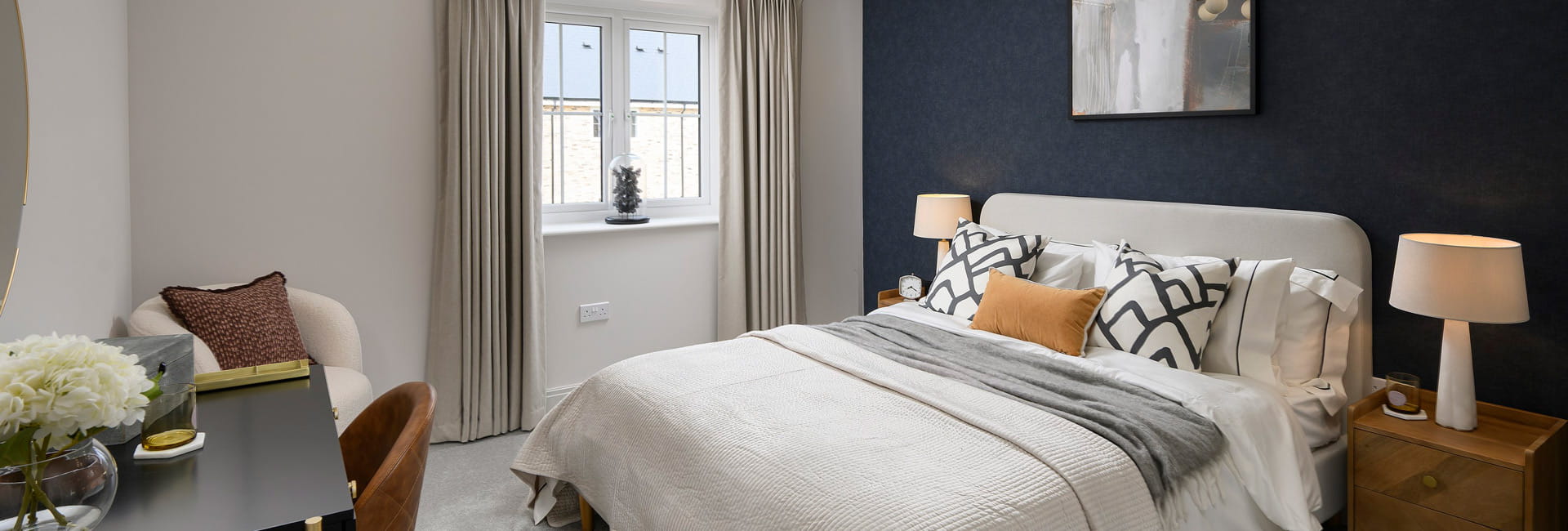 Double bed with contemporary design, bedside tables, table and wall hanging.