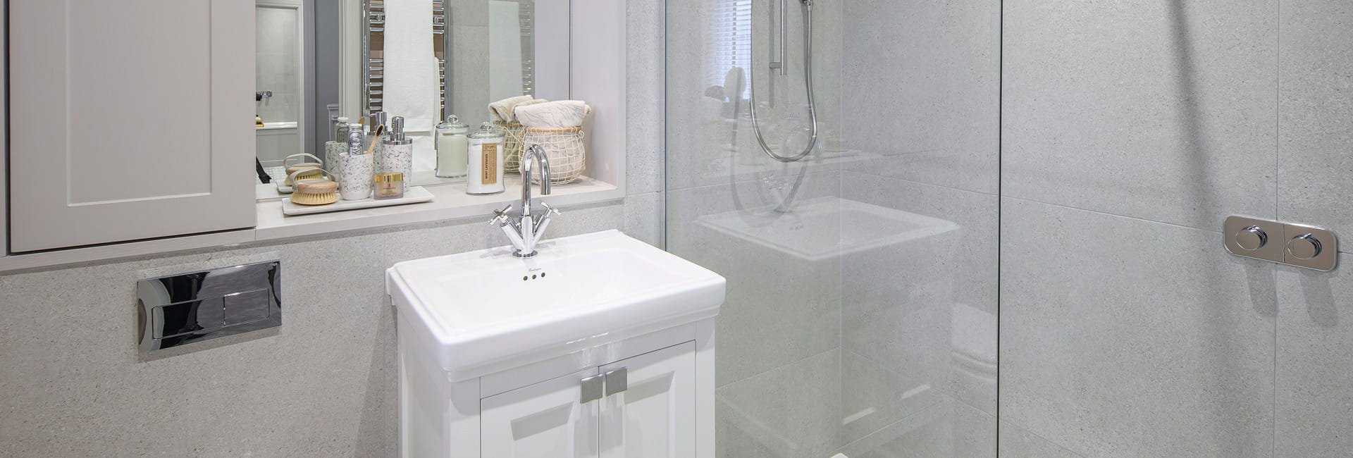 Shower unit with adjacent wash basin, wall mirror and shelving.