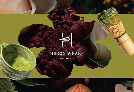 A graphic illustration of Heron Wharf  branding logo against a background of matcha making utensils.