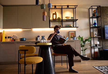 An image of a person sat at the dining table having a drink in their home at Heron Wharf