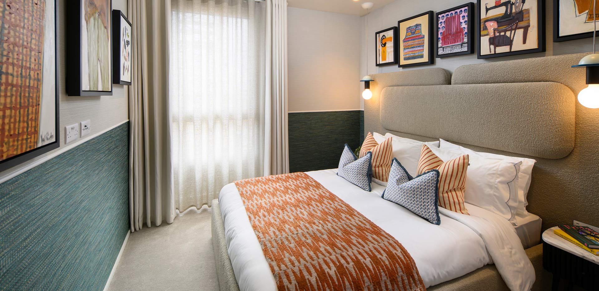 Double bed with contemporary design, bedside tables and wall hanging.