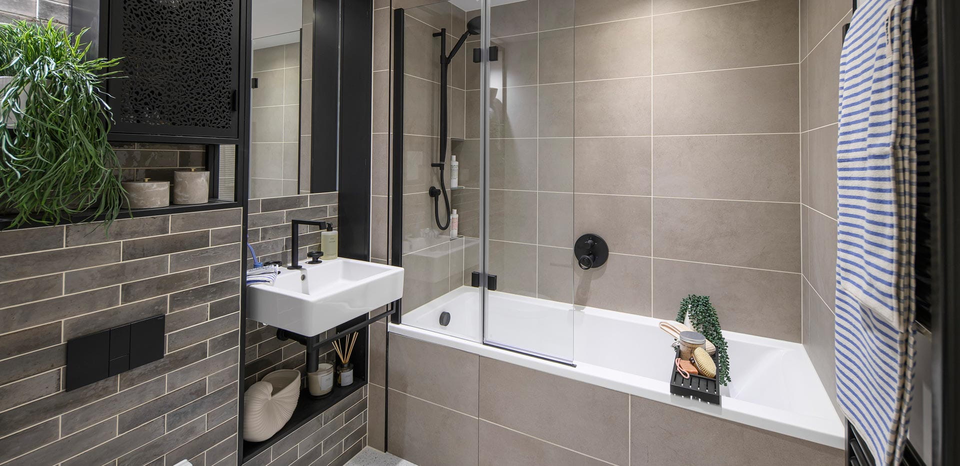 Bathroom with shower over bath, wash basin with cabinet mirror, heated towel rack and shelving.