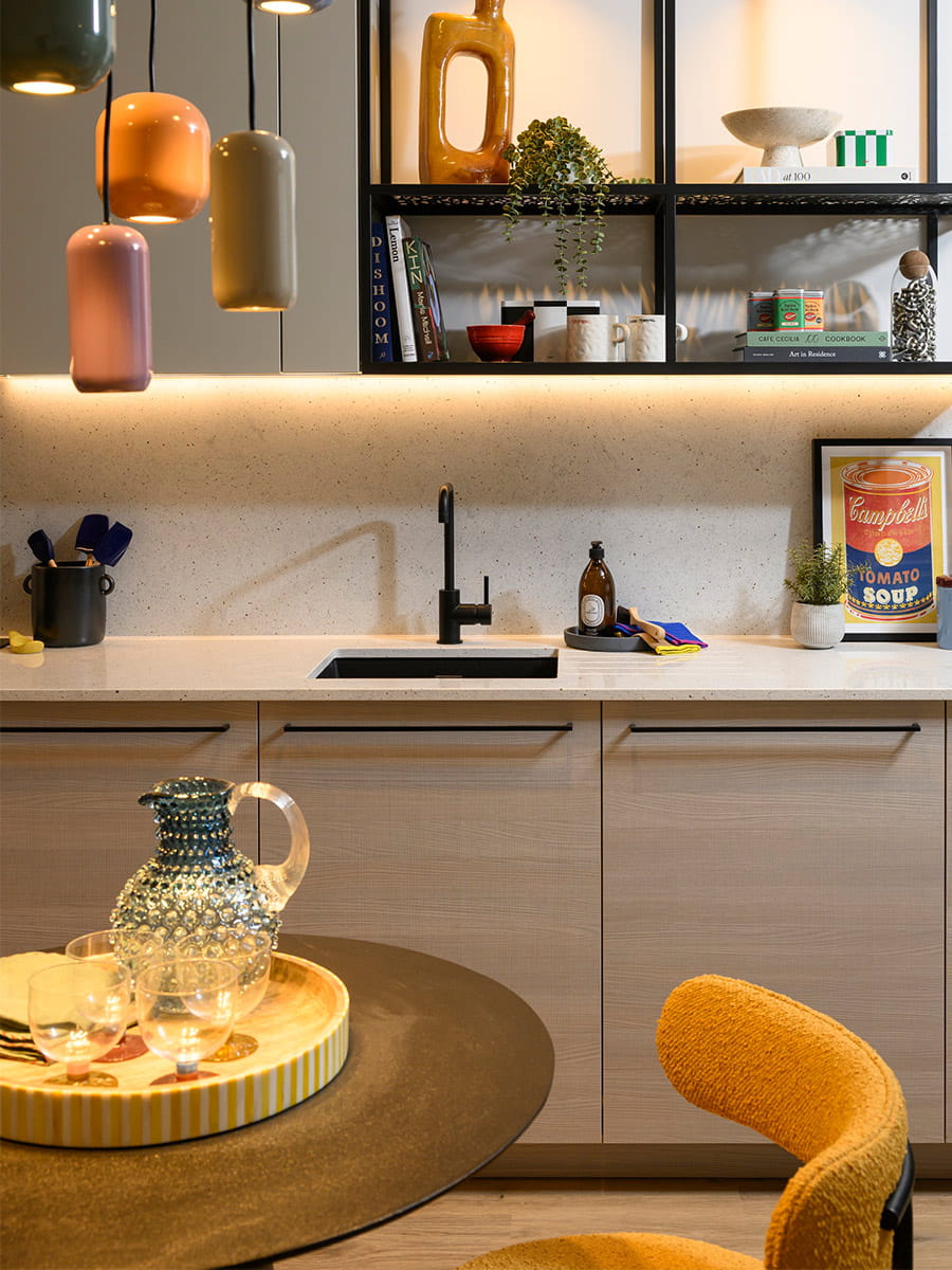  Kitchen, beige cupboard panels and white countertops, modern appliances, dining table in foreground.