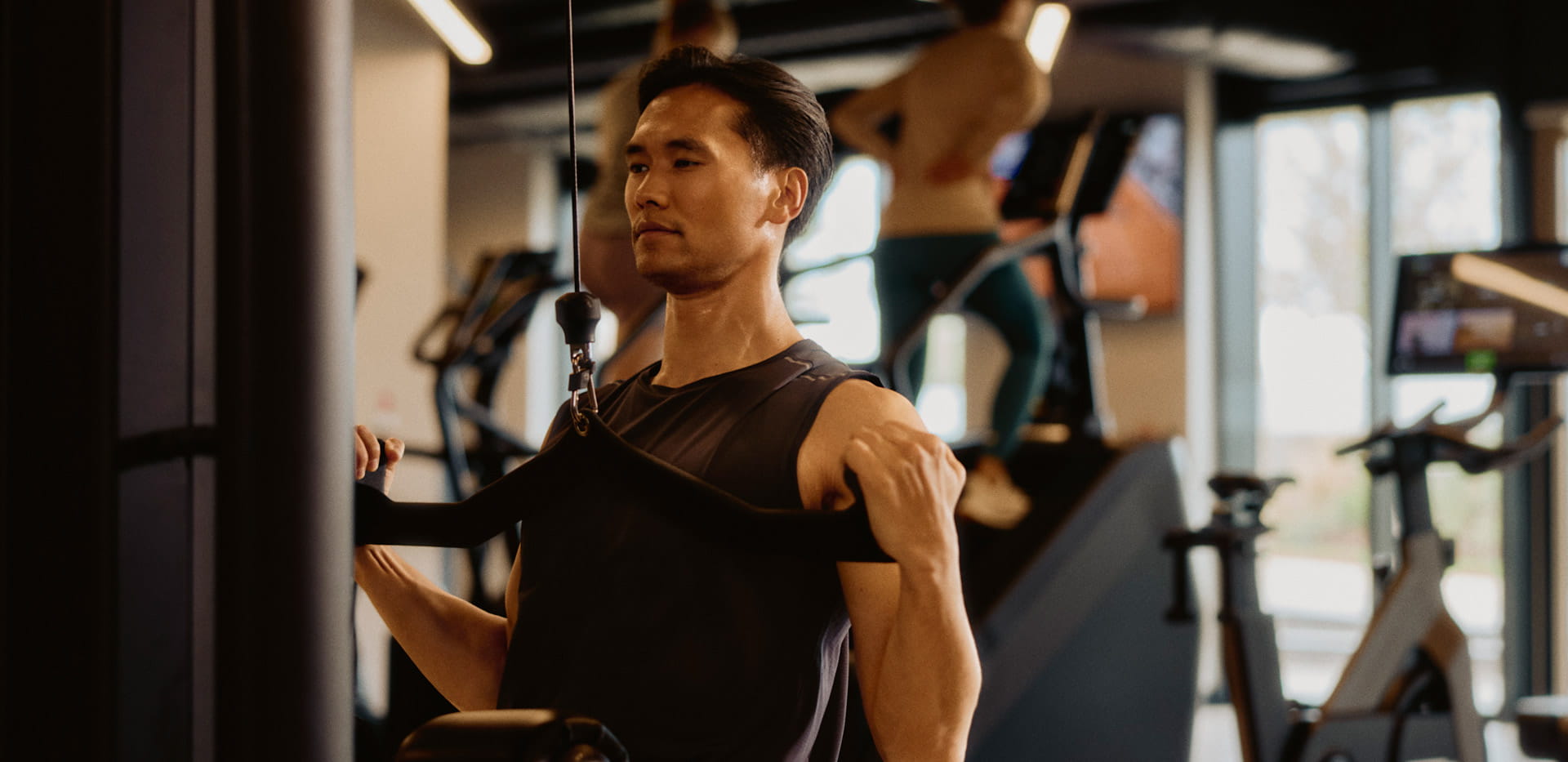 Male in gym attire training on exercise weights machine.
