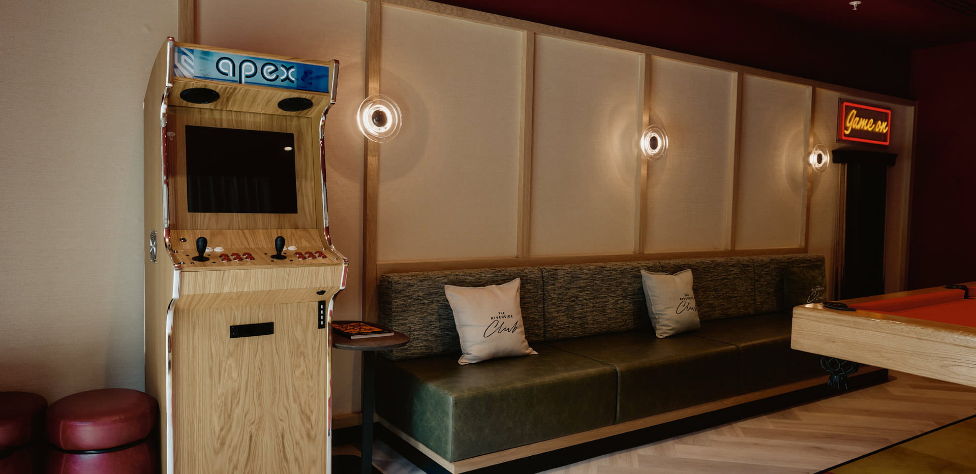 An arcade-style video game machine set in an entertainment room, pool table can be seen in foreground.