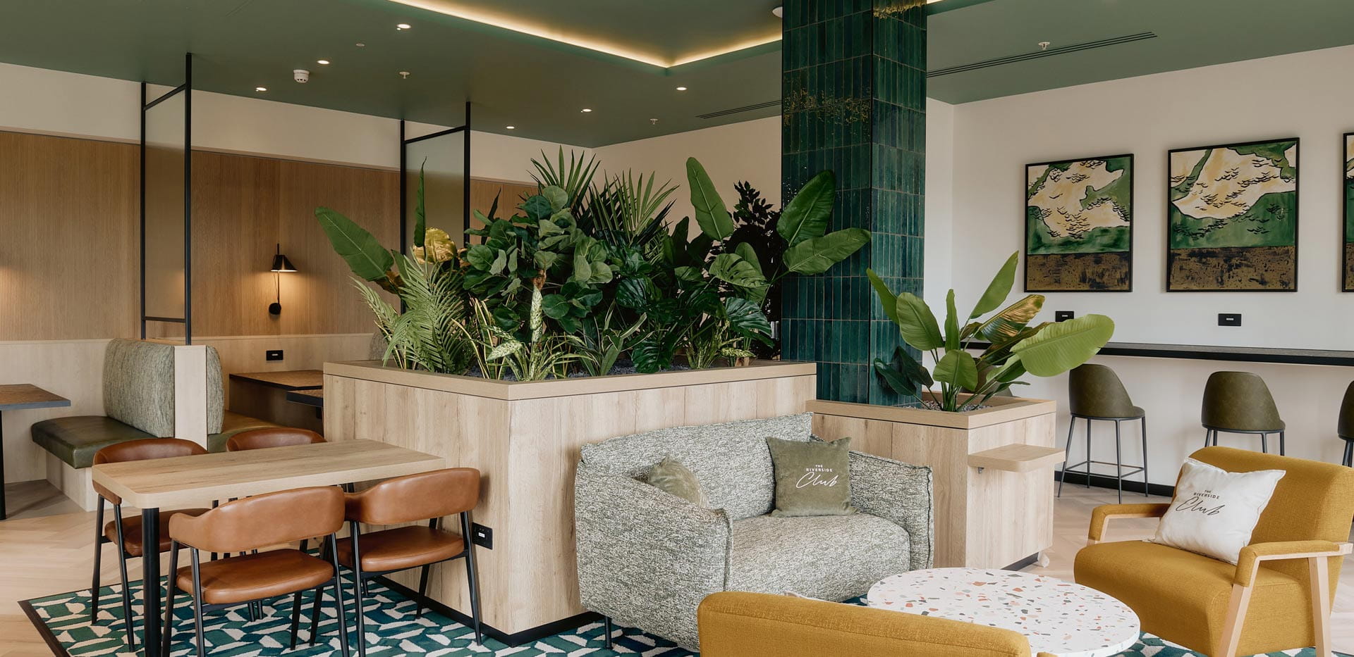 Lounge bar with seating and indoor plants.s