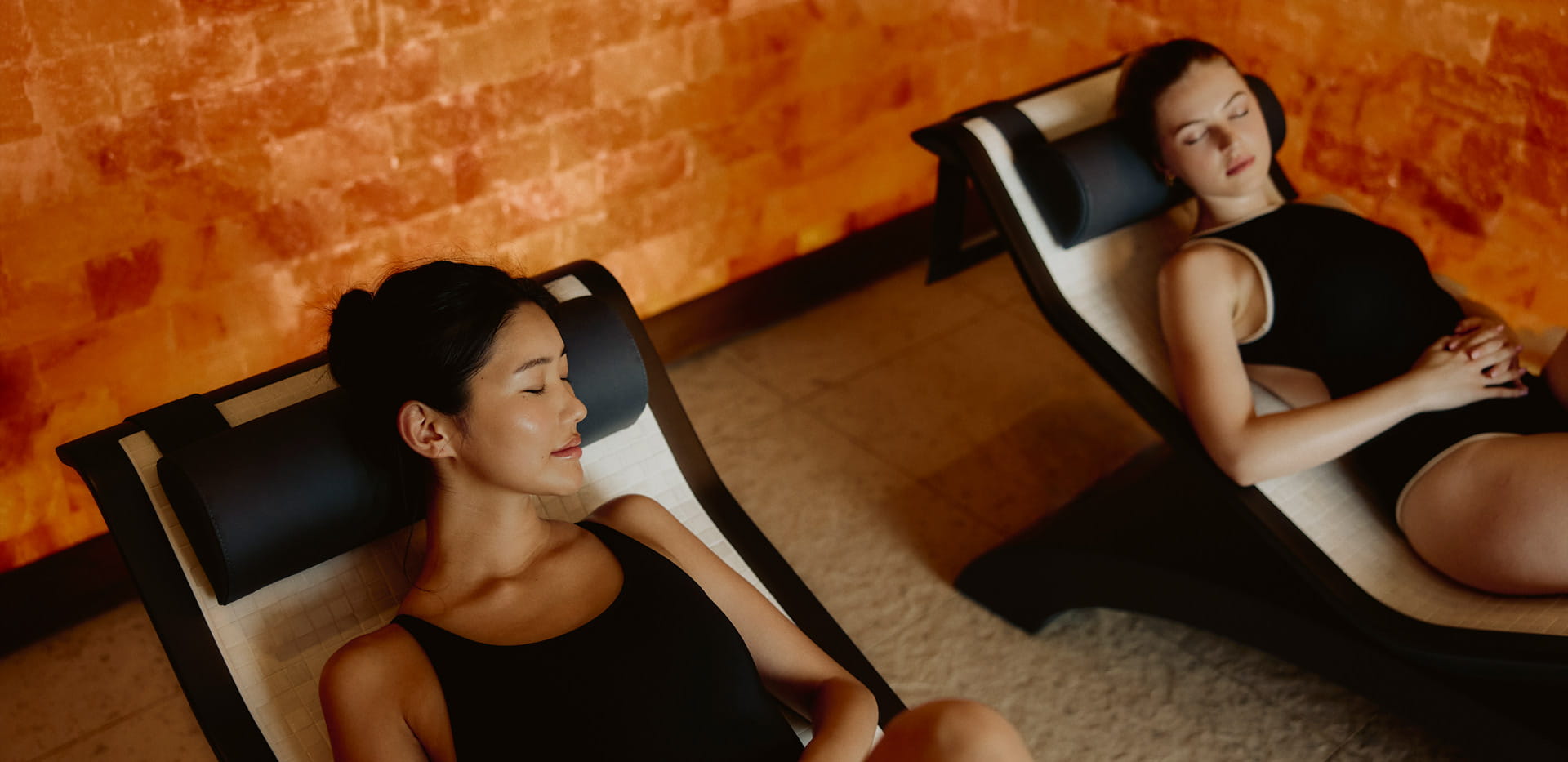 Two females relaxing on lounge chairs in a spa 'salt room'.