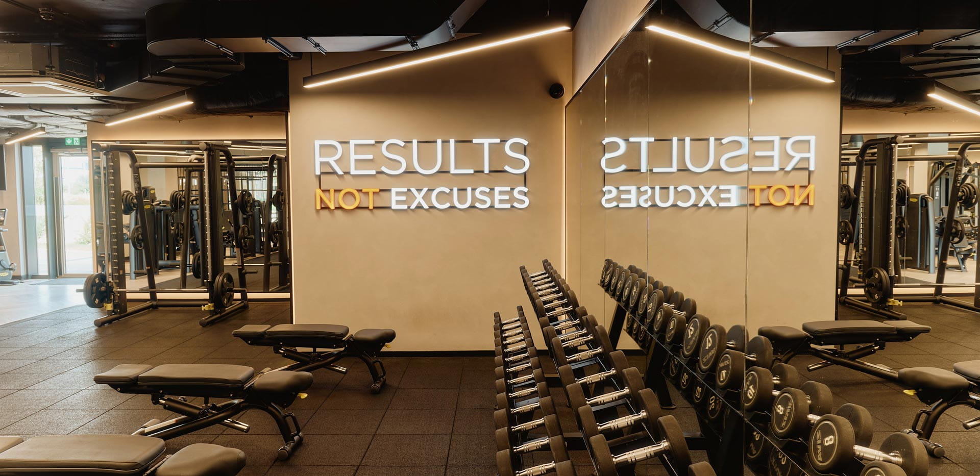 Rack of free weights, wall mirrors and exercise benches.