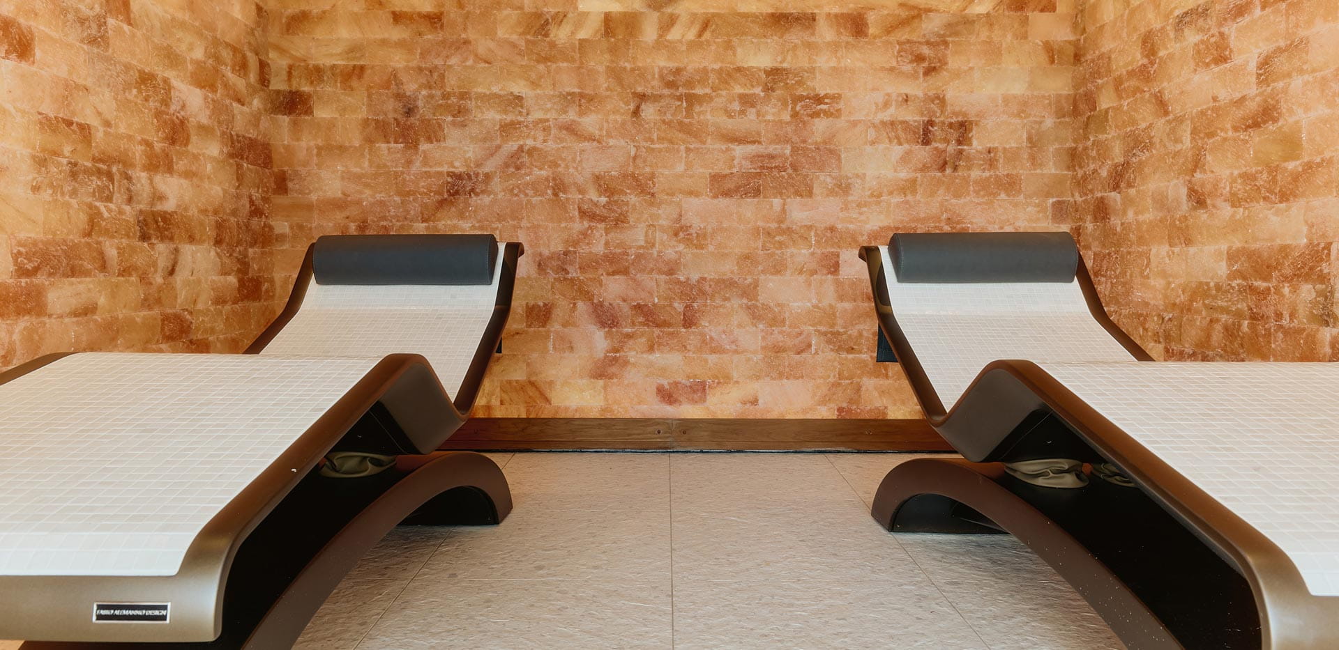 Two sun lounge chairs against an orange stone pattern background.