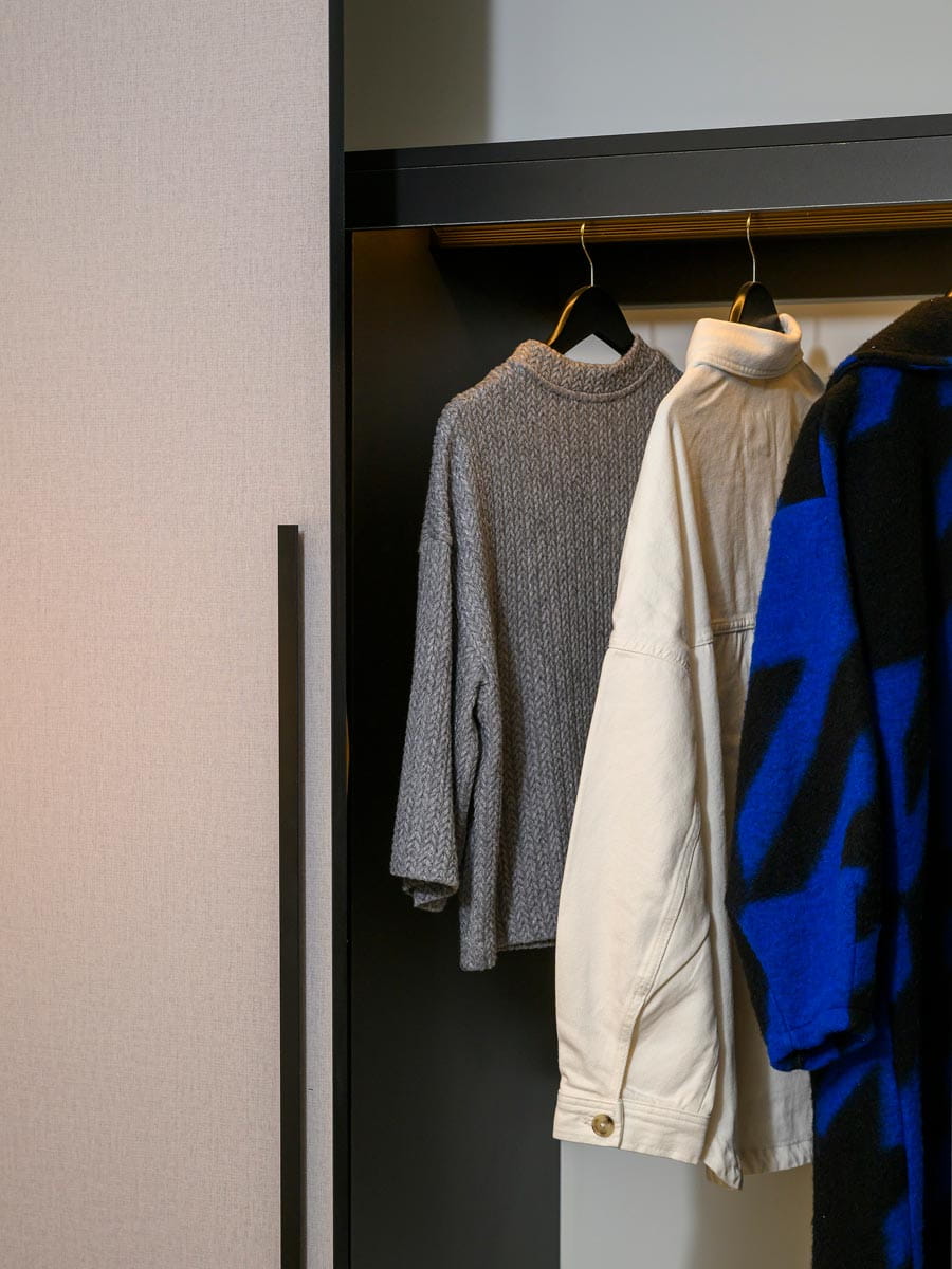 Wardrobe with door ajar and clothes hung up inside