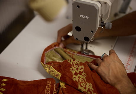 Colourful clothing fabric being worked on a sewing machine.