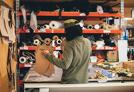 Person examining textile fabrics on a work table.