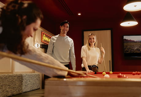 An image of people playing pool at The Riverside Club
