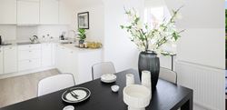 Hollyfields two bedroom apartment kitchen and dining area with a white and black theme