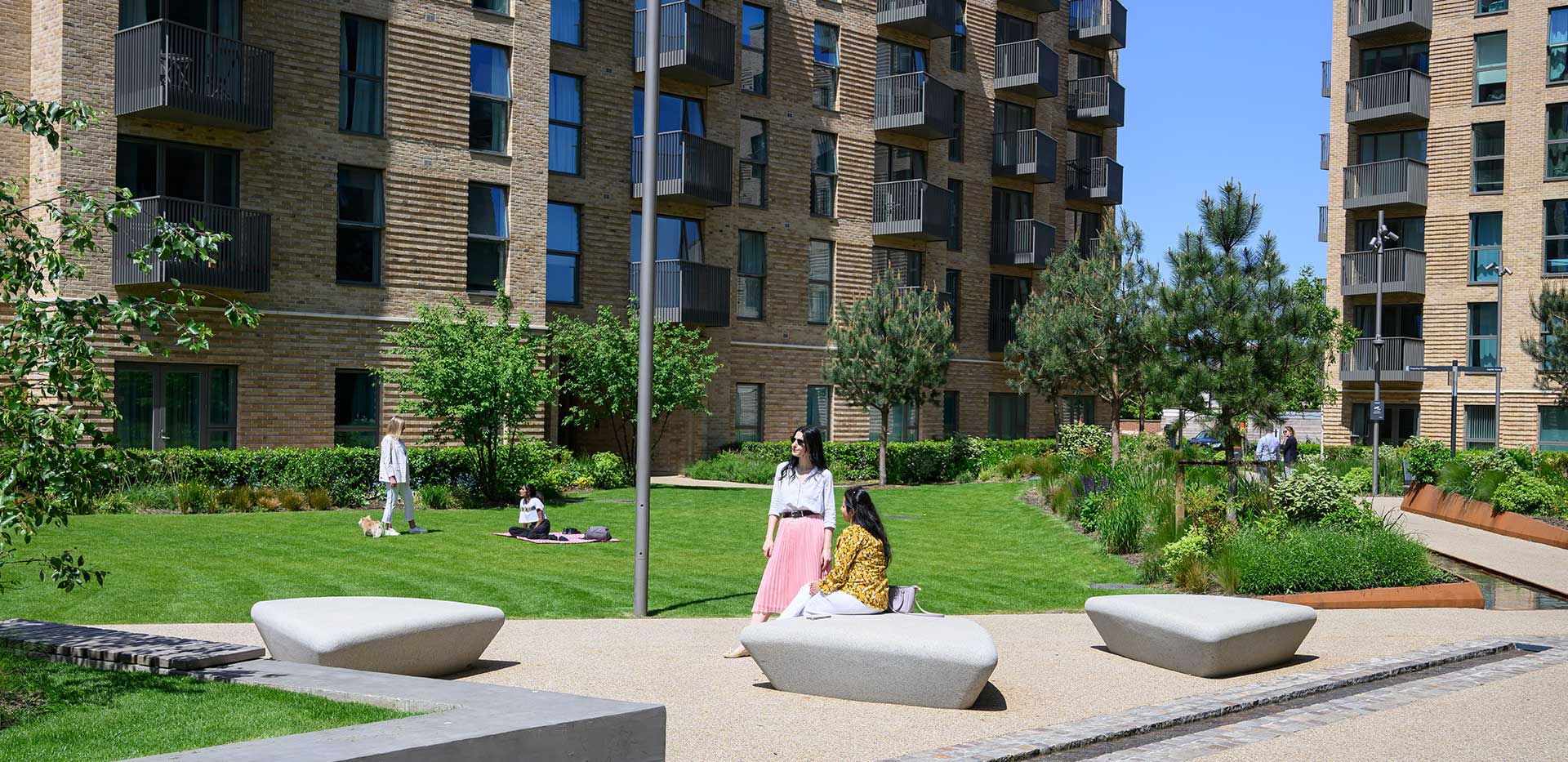 Image of residents walking alongside Aquifer House on a warm sunny day