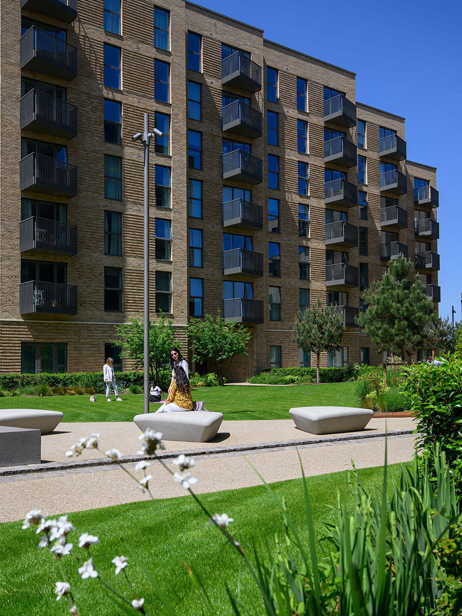 Image of residents walking alongside Aquifer House on a warm sunny day