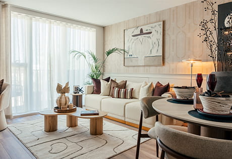 Contemporary designed living space with sofa, coffee table, rug, tall windows and curtains