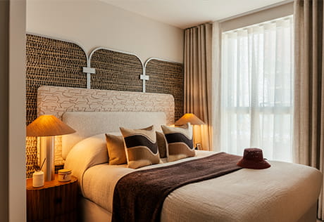 Double bed designed in shades of beige and brown, with bedside tables, headboard.