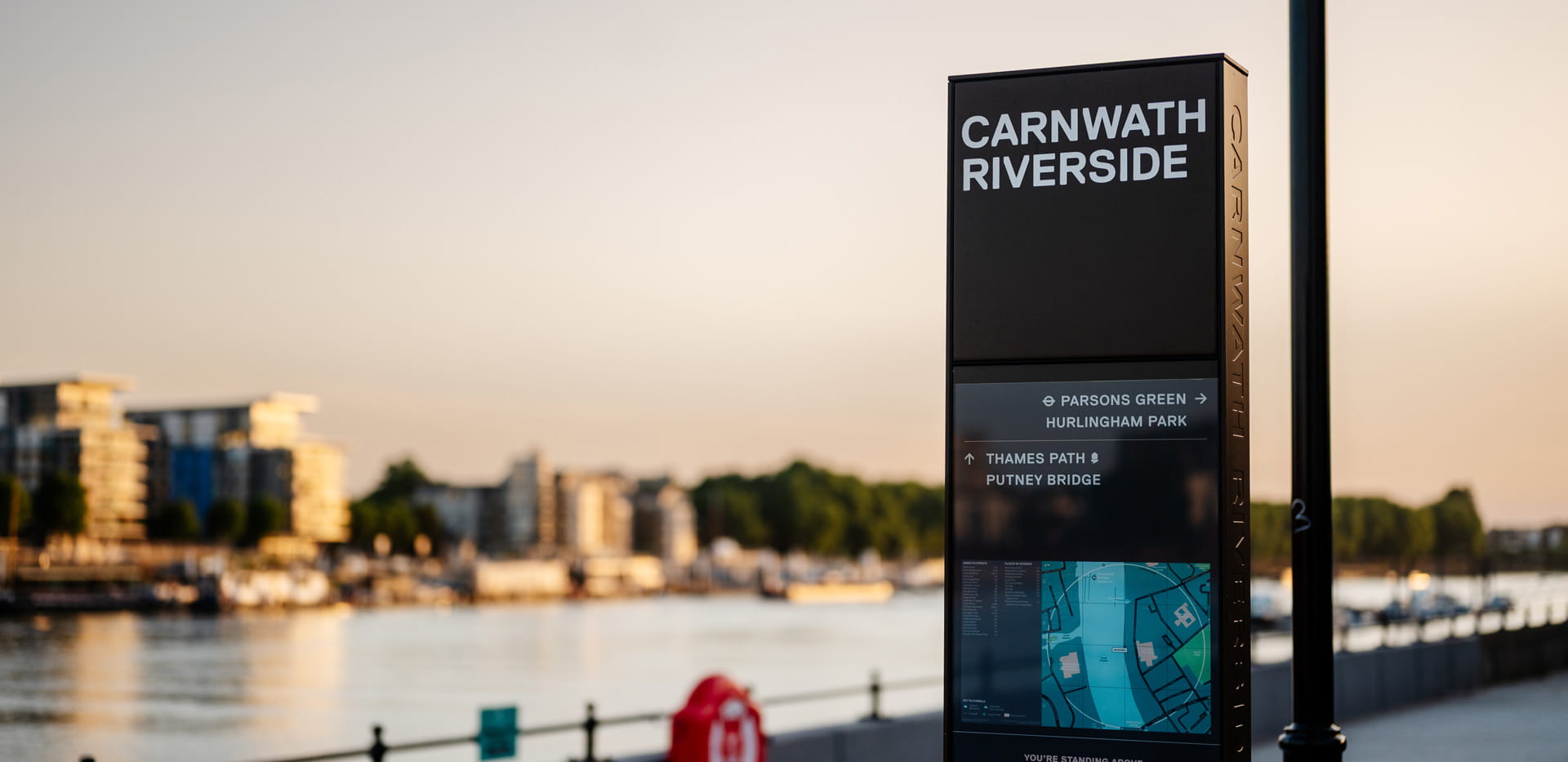 A street information signboard that reads Carnwath Riverside