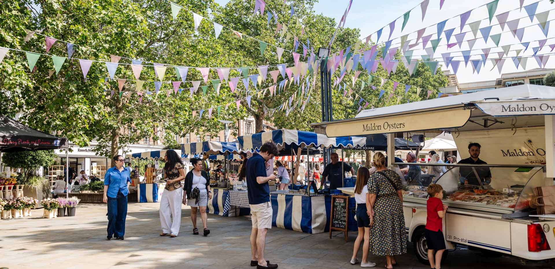 CGI of a pedestrianised area lined with trees and pop-up stalls and shops
