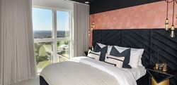 Bedroom with pink, black and white design and large window with view of Waterlily Court