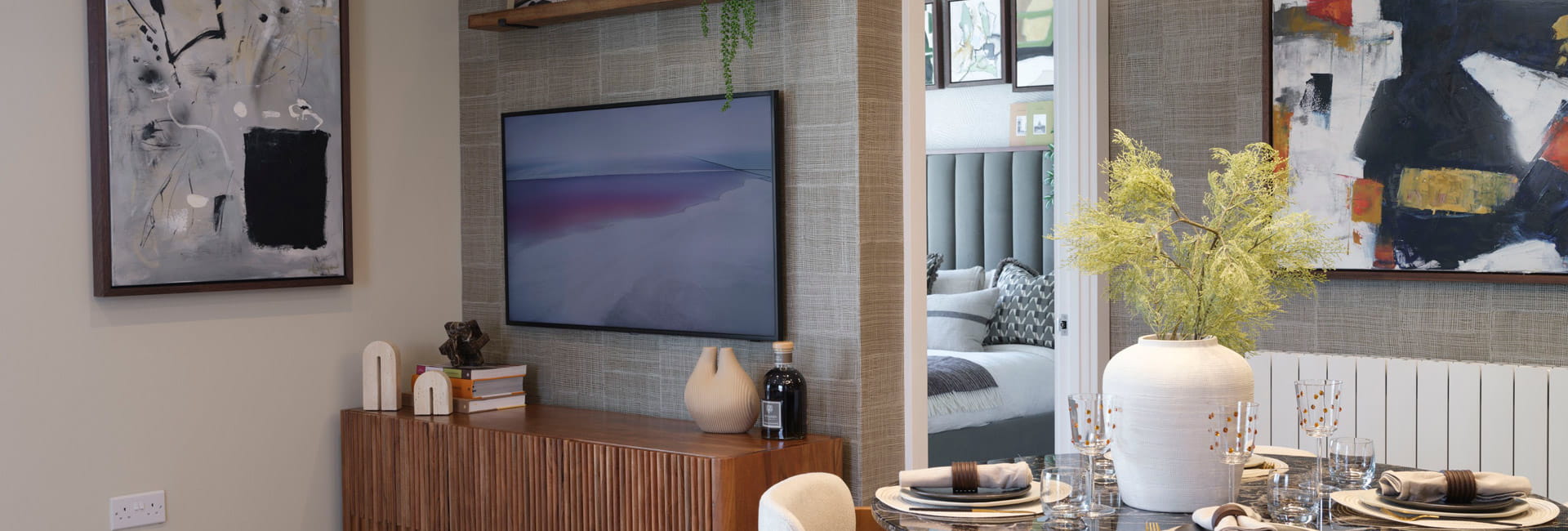 Modern designed living space with TV unit, dining table in foreground.