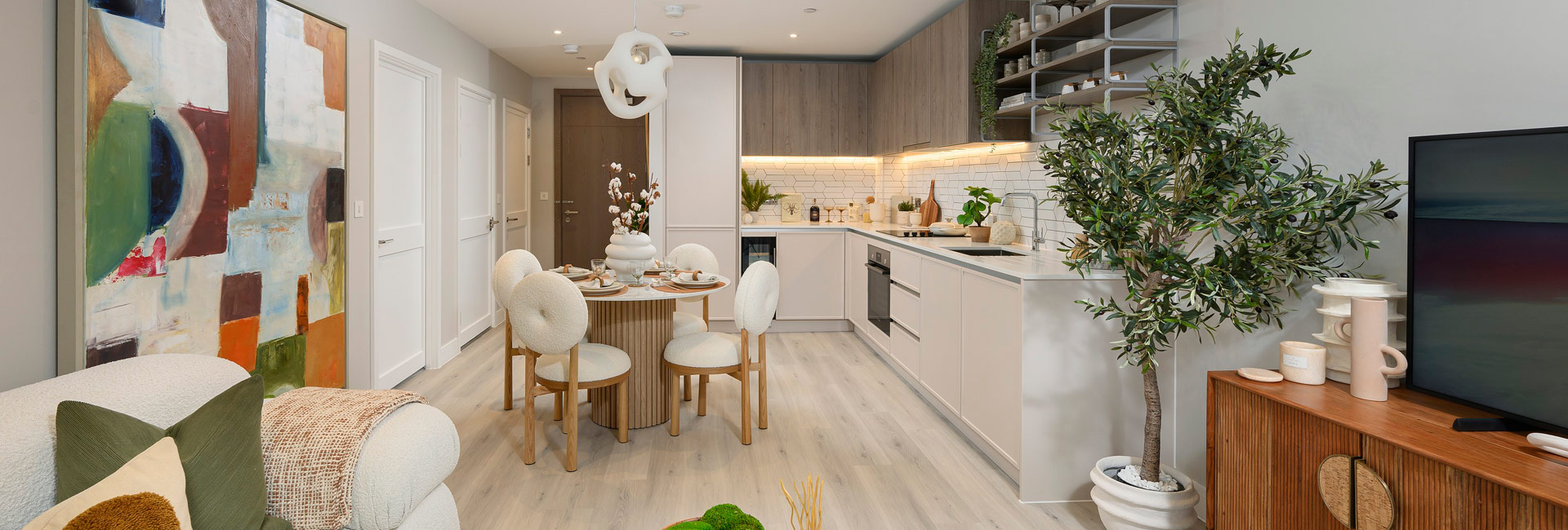 Living space in foreground, kitchen with dining table in background.