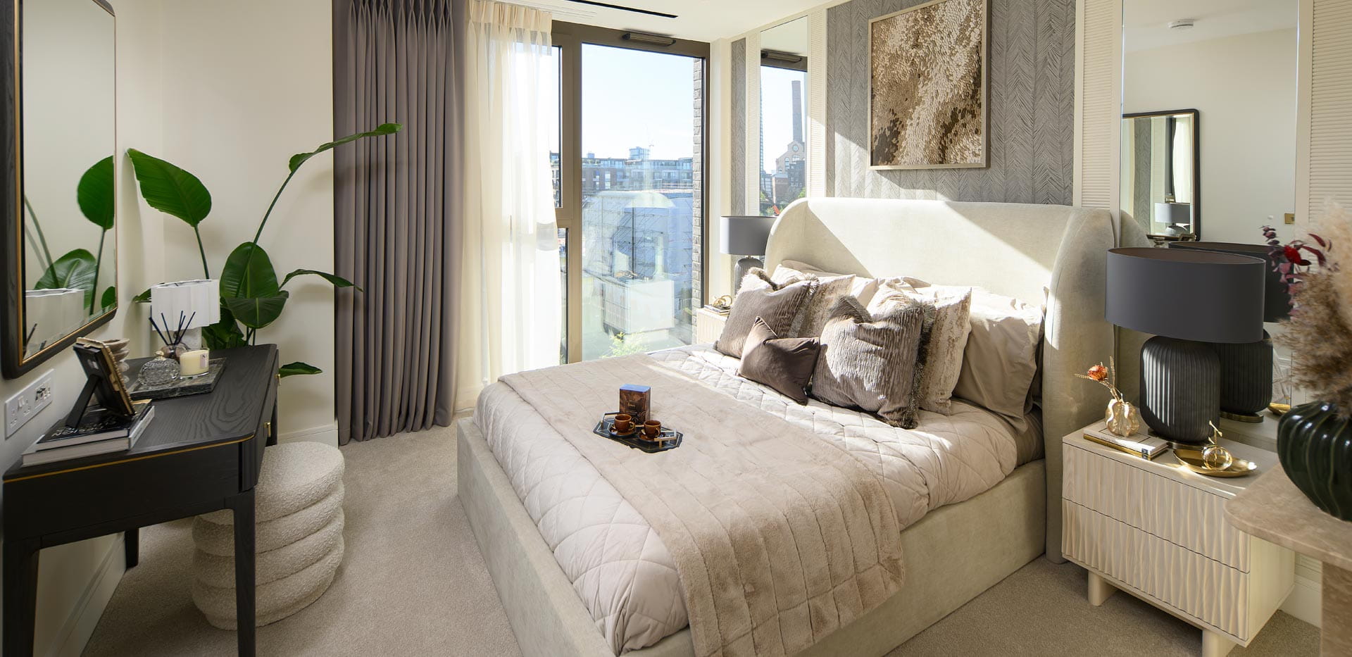Double bed with modern black, beige cream design décor, floor to ceiling window and vanity table