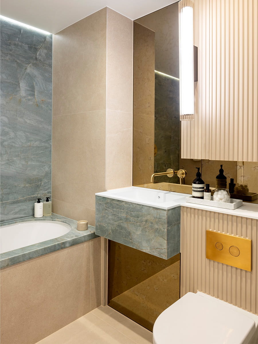 Partial view of bathtub, wash basin, cabinet space and toilet, modern design decorations