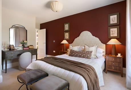 Contemporary design bedroom with end of be seats, vanity table, carpet flooring.