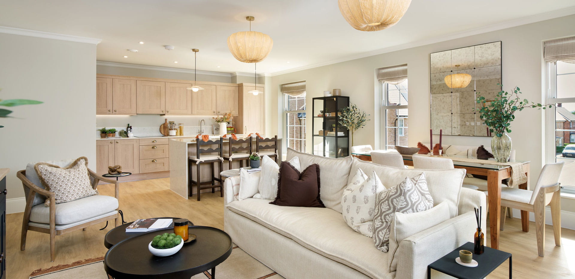 Contemporary style living space in foreground, dining table and kitchen in background.