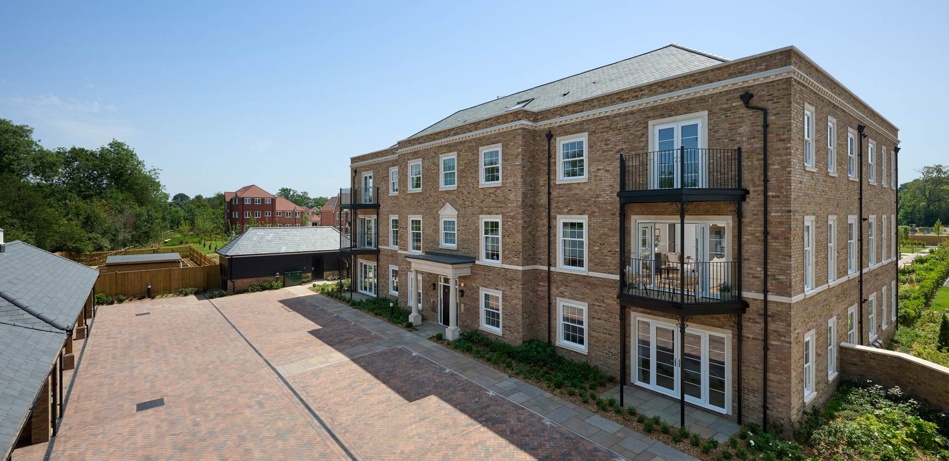 Exterior development façade, rear driveway and sheltered parking area.