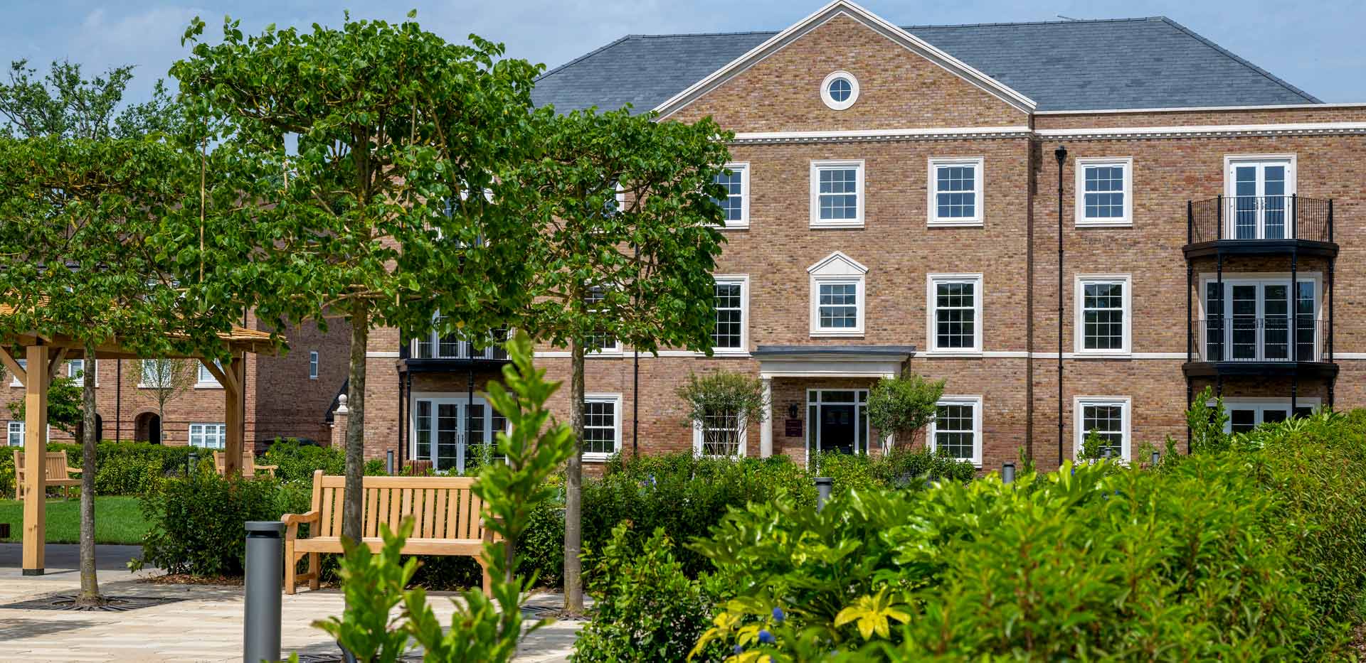 CGI of external development housing facades and landscaping in foreground.
