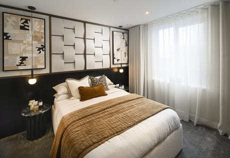 modern designed bedroom with abstract wall hangings, carpet flooring, ample natural lighting