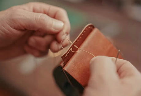 An image of a person stitching leather