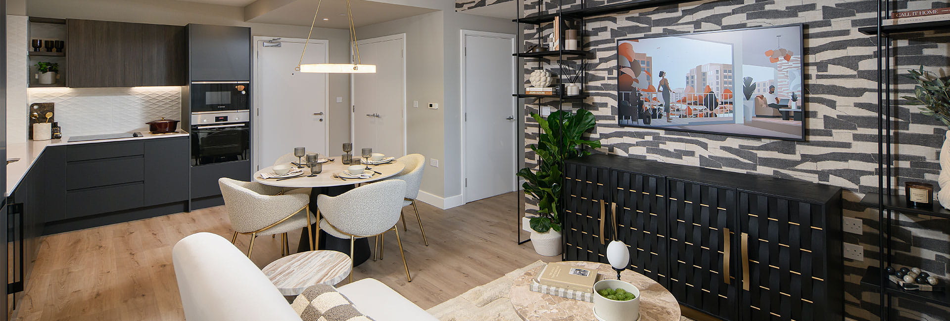 Modern open-plan living area with dark kitchen, round dining table, patterned feature wall and marble coffee table.