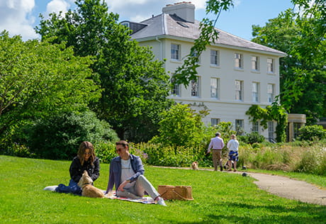 Exterior photo of residents enjoying the sun and greenery at Oakhill House