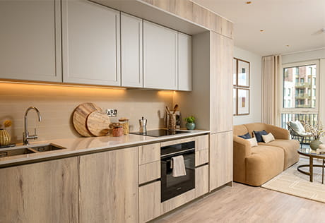 Modern open-plan kitchen, dining and living room with balcony seating and distant city skyline view.