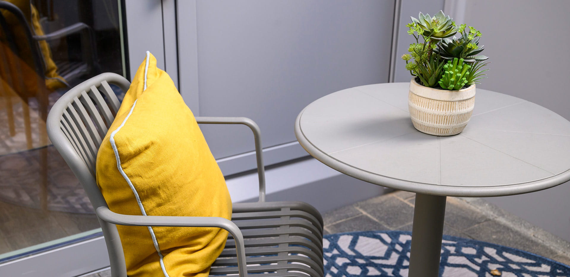 An image of a table and chair on a balcony of a Berkeley development