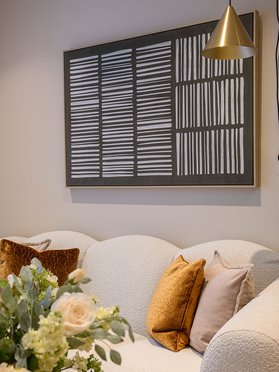 A living room image with a large canvas painting above the sofa