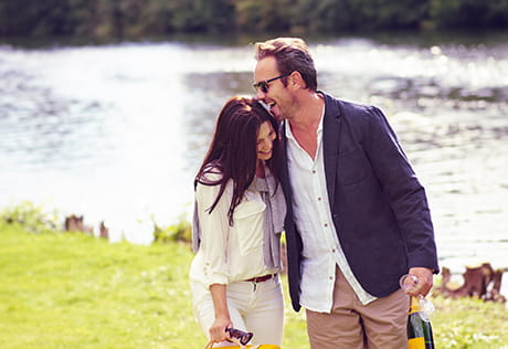 An image of a couple walking along the river together
