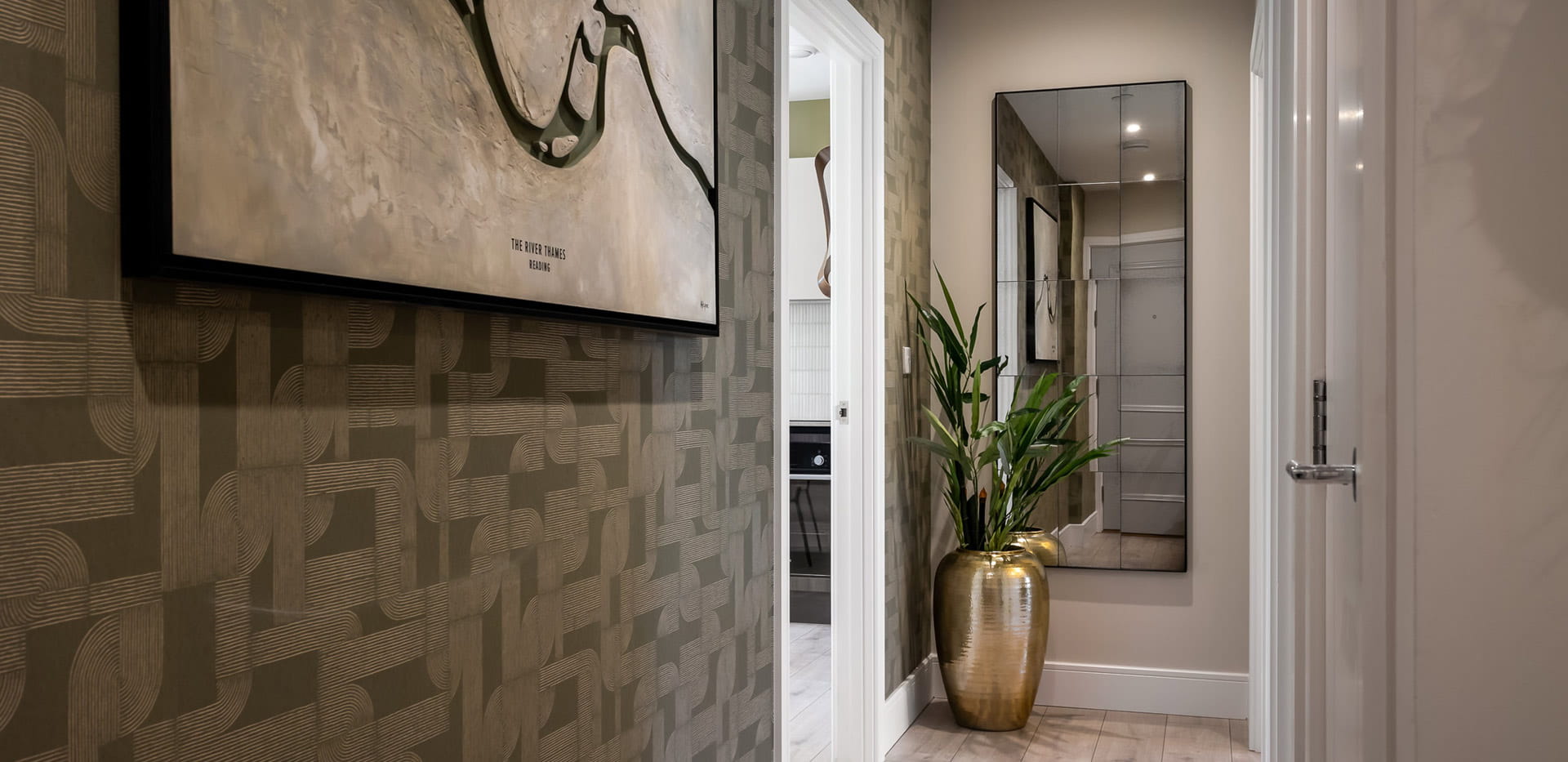 Hallway with indoor plant, wall hanging and wall mirror