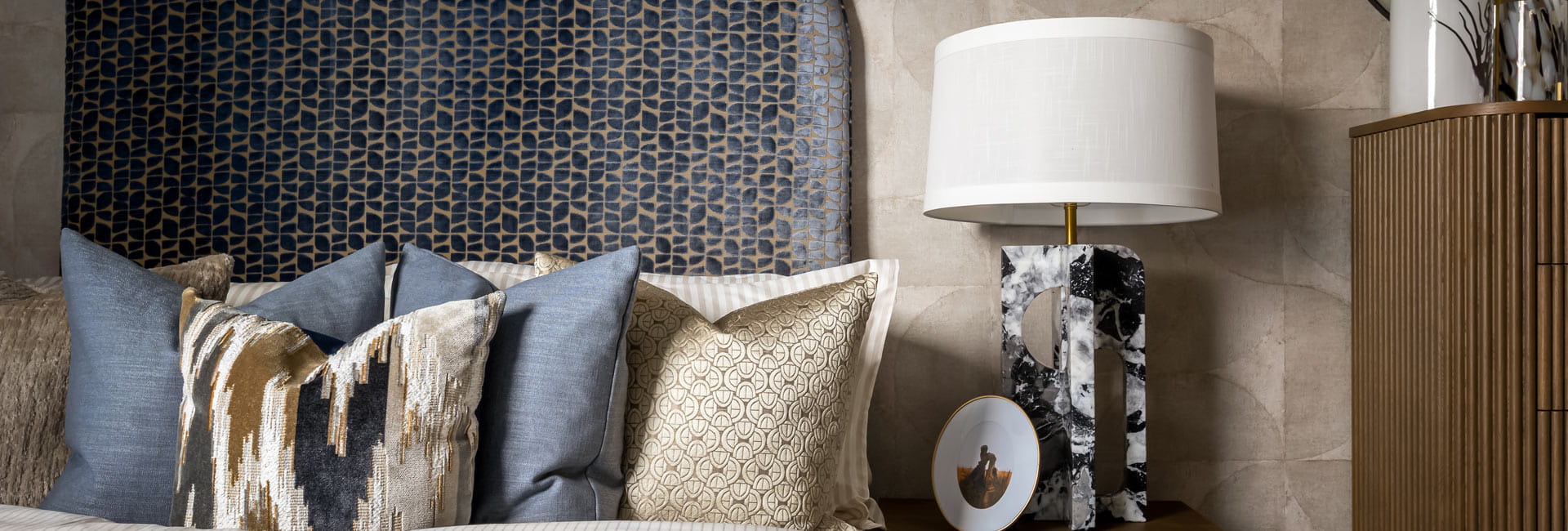 Closeup view of bedside decorated in royal blue and beige tones.